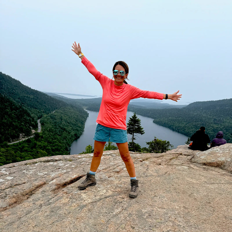 Woman hiking in coral sun shirt 