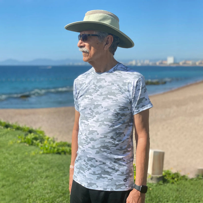 man on the beach wearing gray camo sun protection shirt with cowboy hat