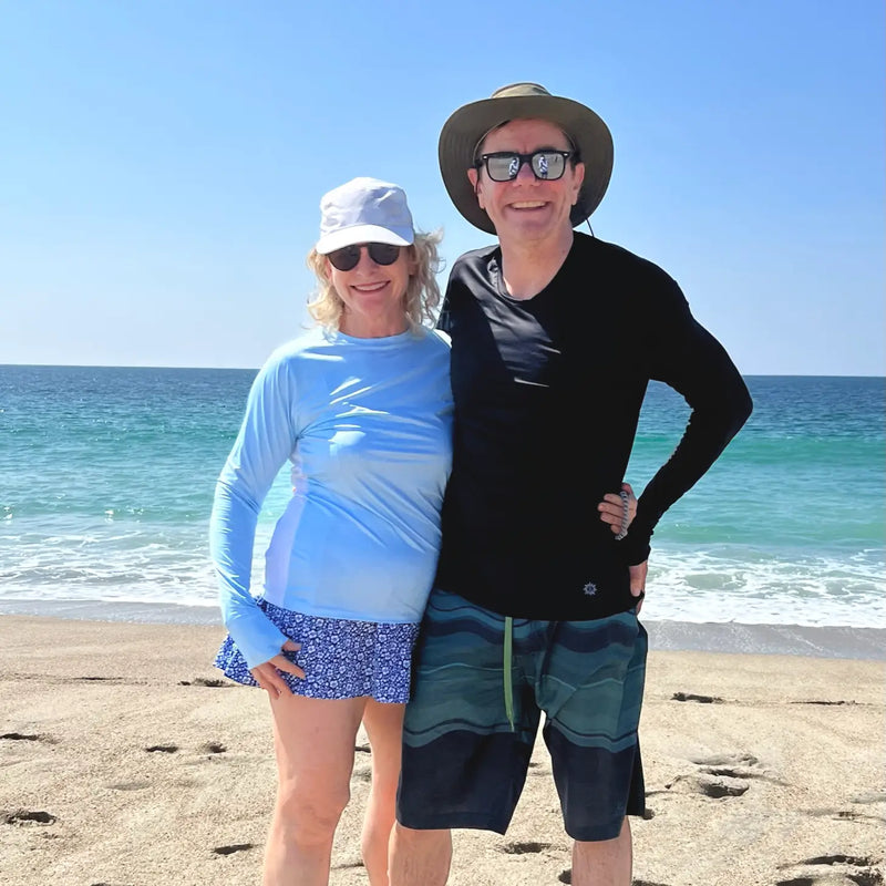 Couple smiling on the beach wearing Belesun sun protection shirts
