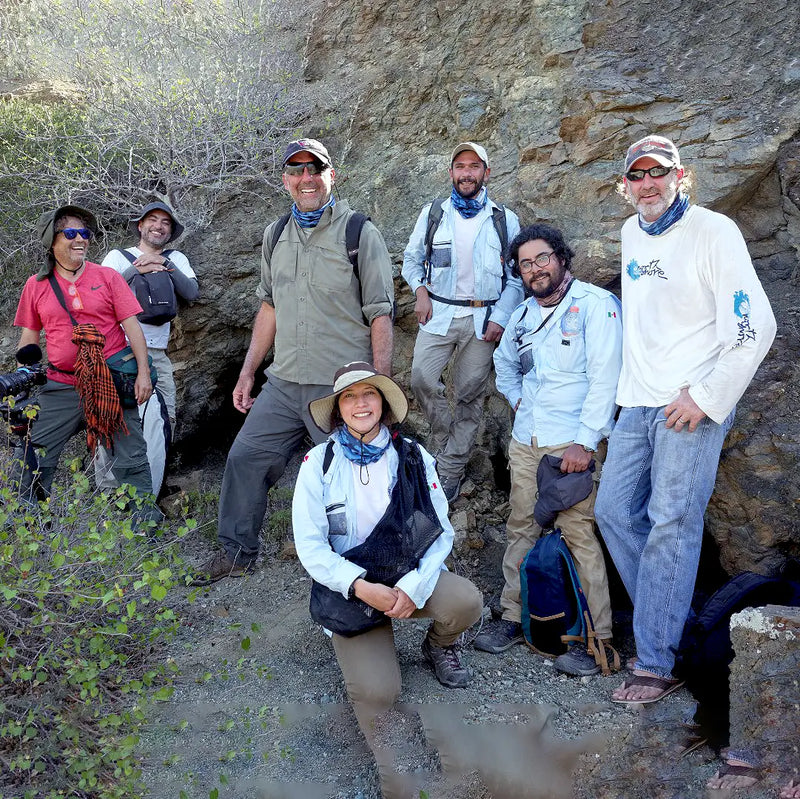 group of hikers posing near a mountain wearing sun protection neck gaiters