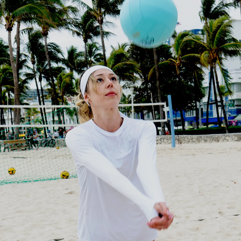 woman wearing sun protection shirt by Belesun while playing volleyball on the beach
